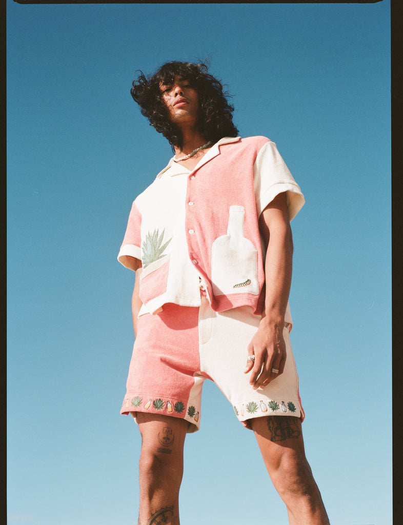 Male Model pictured from below, wearing full 'Gusanito' Cabana Set with his brown hair blowing in the wind.