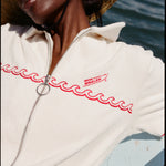 Female model wearing a large beige sunhat sitting on a boat while wearing the 'Boston Whaler' Cabana (white).