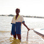 Female model holding a rope attached to a boat while standing in knee-high water wearing the 'boston whaler' no nibbles cabana.