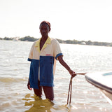 Female model holding a rope attached to a boat while standing in knee-high water wearing the 'boston whaler' no nibbles cabana.