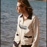 Man standing in front of water, wearing Long Sleeve 'Blubber' Cabana, and staring out to the side. 
