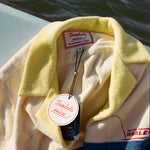 Close-up product image of the 'Boston Whaler' No nibbles cabana interior tag with both Tombolo and Boston Whaler logos, and text that reads: 'the unsinkable legend.'