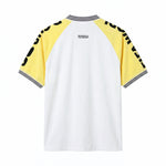 Back view of a white terry cloth shirt with yellow raglan sleeves, black printed lettering along the sleeves, a black-and-white striped ribbed collar and cuffs, and a small embroidered Tombolo logo centered below the neckline.