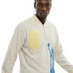 Close view of model wearing beige long sleeve terry quarter zip with FIFA World Cup New York New Jersey patch and Statue of Liberty print.