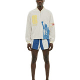 Model wearing beige terry long sleeve quarter zip with FIFA World Cup graphic and Statue of Liberty print.