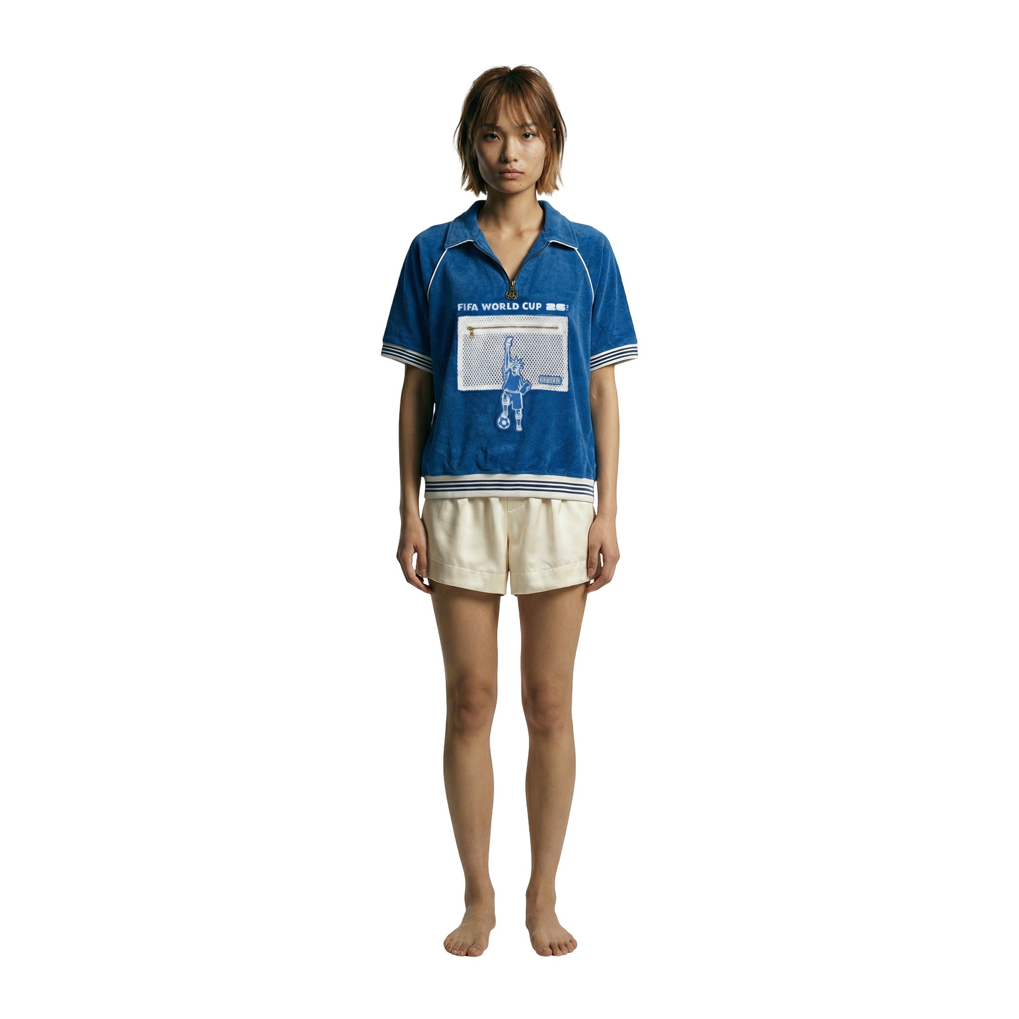 Model wearing blue terry FIFA World Cup cabana shirt with white trim, quarter zip collar, and front mesh pocket.