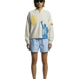 Model wearing beige long sleeve terry quarter zip with FIFA World Cup graphics and Statue of Liberty print.