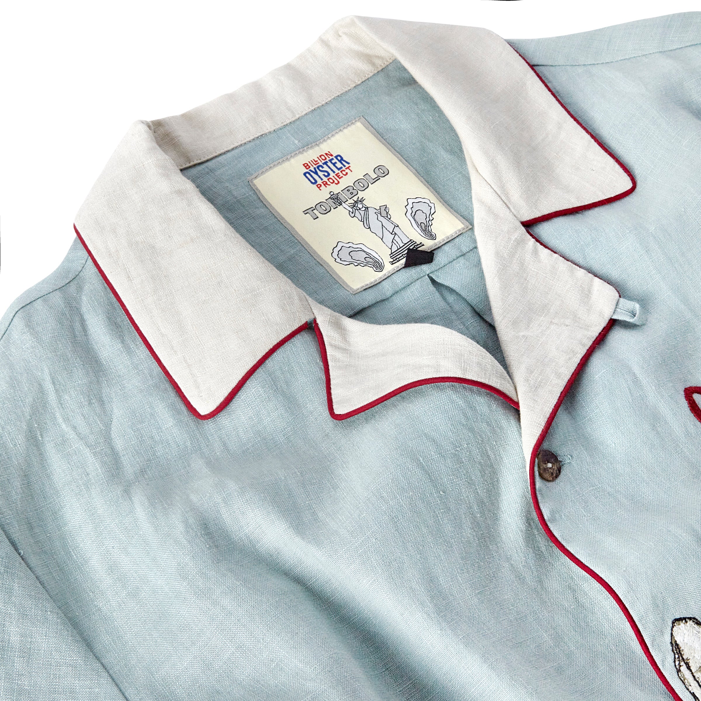 close up of inside shirt label with Billion Oyster Project and Tombolo logos