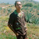 Man standing in a field wearing full cabana set (shirt and shorts).