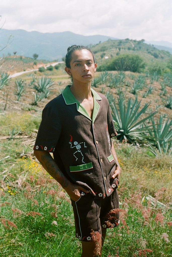 Man standing in a field wearing full cabana set (shirt and shorts).