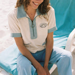 girl smiles and looks downwards wearing terrycloth oyster shirt