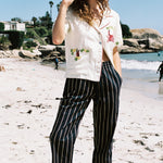 Woman eating ice cream with one hand in her pocket, looking down