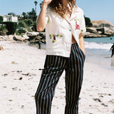Woman eating ice cream with one hand in her pocket, looking down