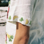 close up of side view of sleeved, showing emboridered lemons and leaf motifs