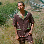 Man standing in a field wearing full cabana set (shirt and shorts).