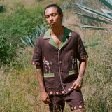 Man standing in a field wearing full cabana set (shirt and shorts).