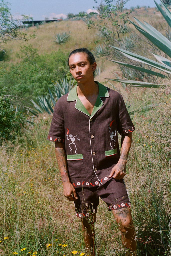 Man standing in a field wearing full cabana set (shirt and shorts).