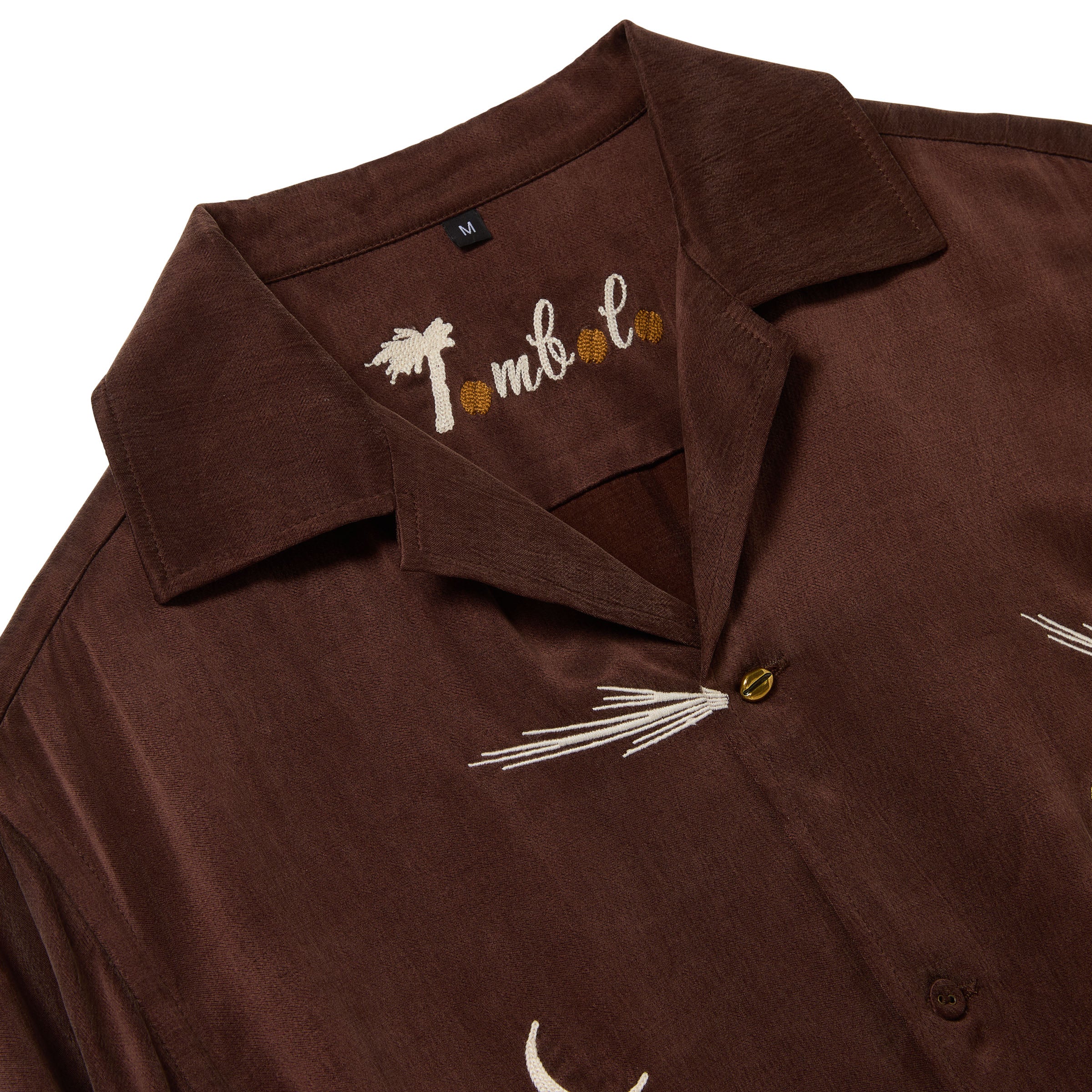 Close up on collar, featuring a chain-stitched 'Tombolo' logo, with espresso beans in place of the 'O's'. 