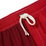 Close-up of red trunks with a white drawstring on a white background