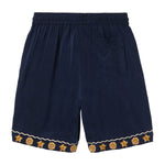 Navy shorts with gold starfish patterns on a white background