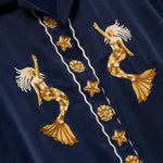 Embroidered mermaid and starfish design on a navy blue fabric