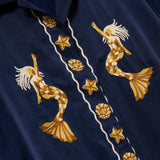 Embroidered mermaid and starfish design on a navy blue fabric