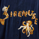 Navy blue shirt with gold mermaid, fish, and octopus embroidery on a dark background