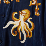 Embroidered octopus design on a dark blue fabric background