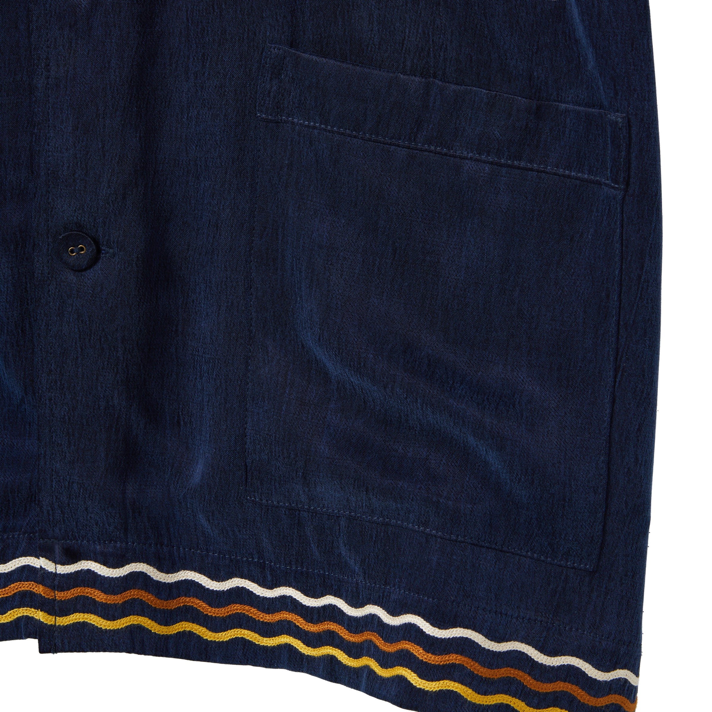 Navy blue shirt with a pocket and colorful stripe at the hem on a white background