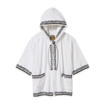 White short-sleeve terry cloth hooded beach towel top with black embroidered trim, black embroidered surf board, two pockets, and frayed edges. 