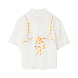 Back of white seersucker shirt, with embroidered bikini ties across the back. 