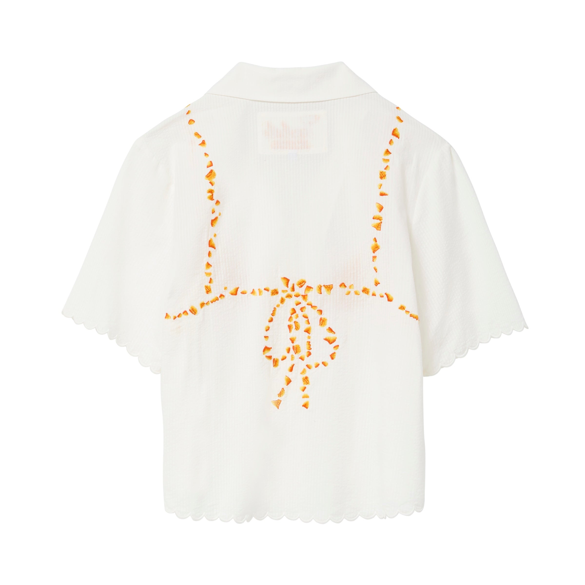 Back of white seersucker shirt, with embroidered bikini ties across the back. 