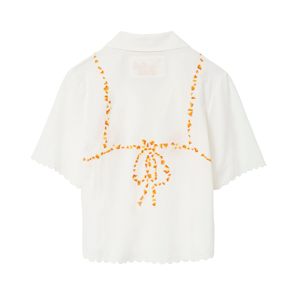 Back of white seersucker shirt, with embroidered bikini ties across the back. 