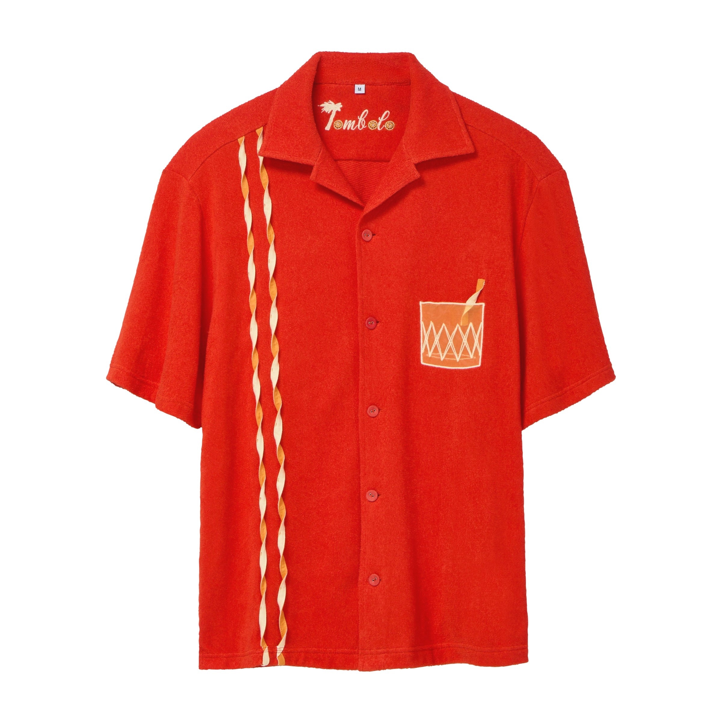 Red short-sleeve cabana shirt featuring an embroidered Negroni glass on the chest pocket and three twisted appliqué stripes running down one side. The shirt has matching red buttons and a chain-stitched “Tombolo” logo at the collar.

