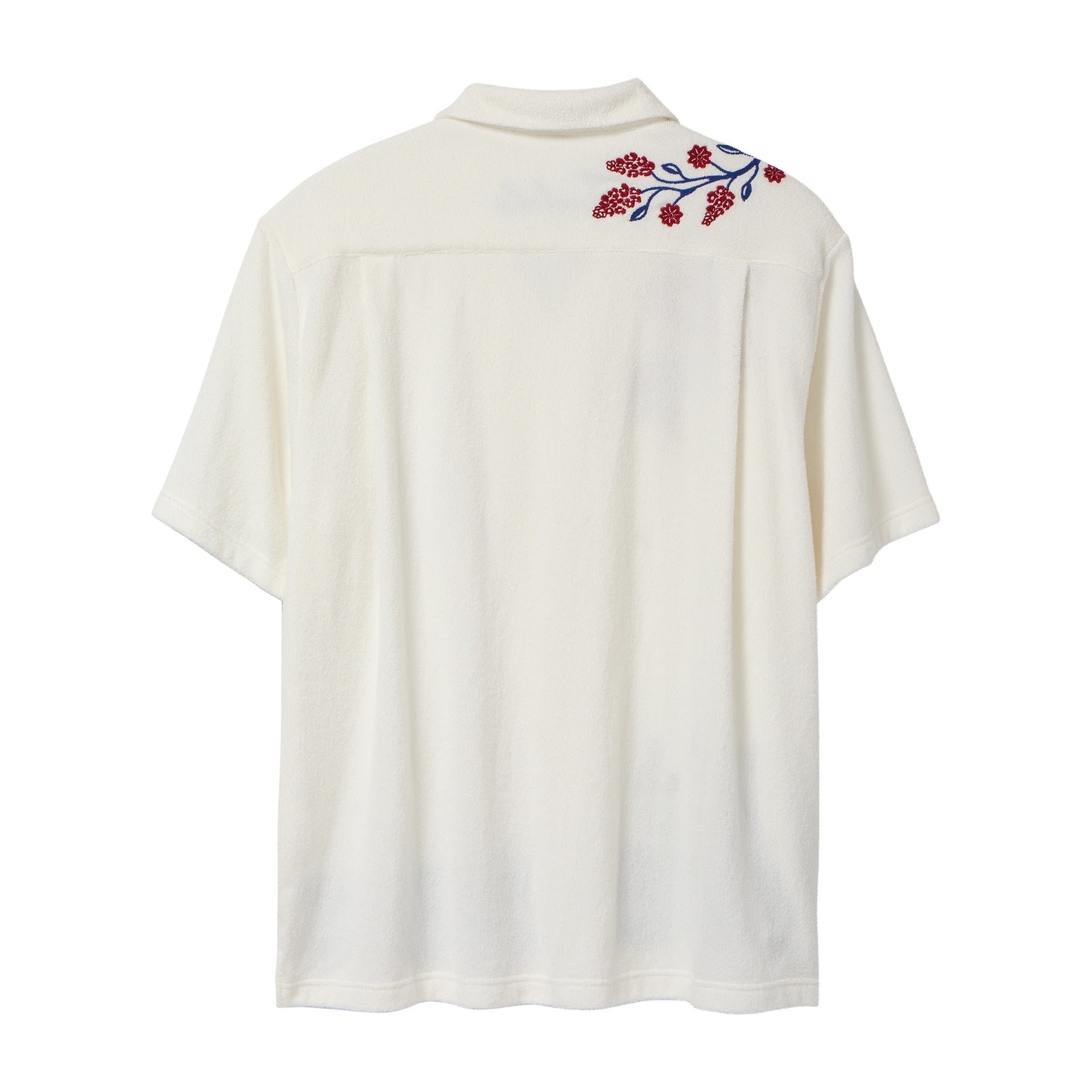 Back view of a cream terry cabana shirt with embroidered red floral vines and blue leaves on the shoulder.