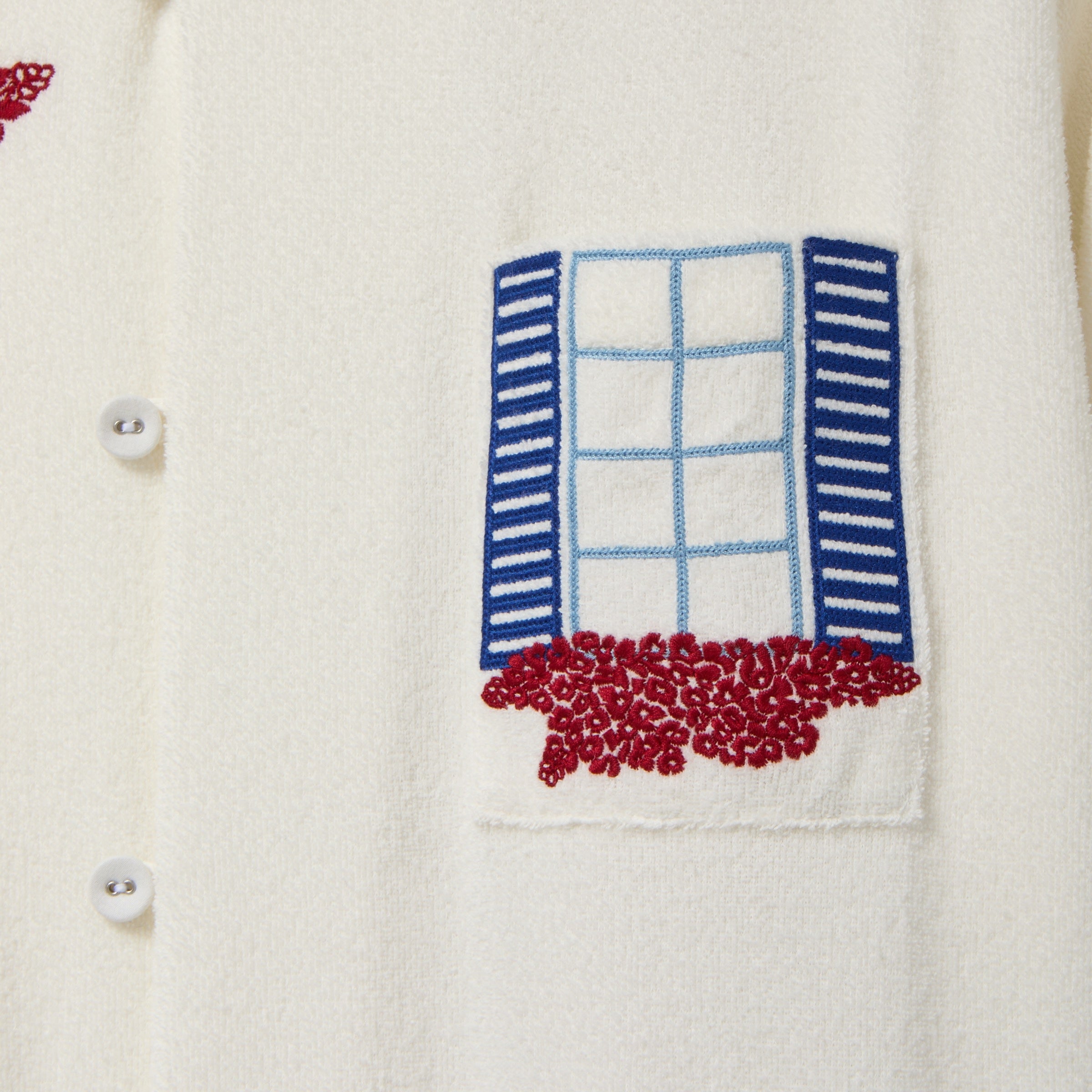 Embroidered design of a window with shutters