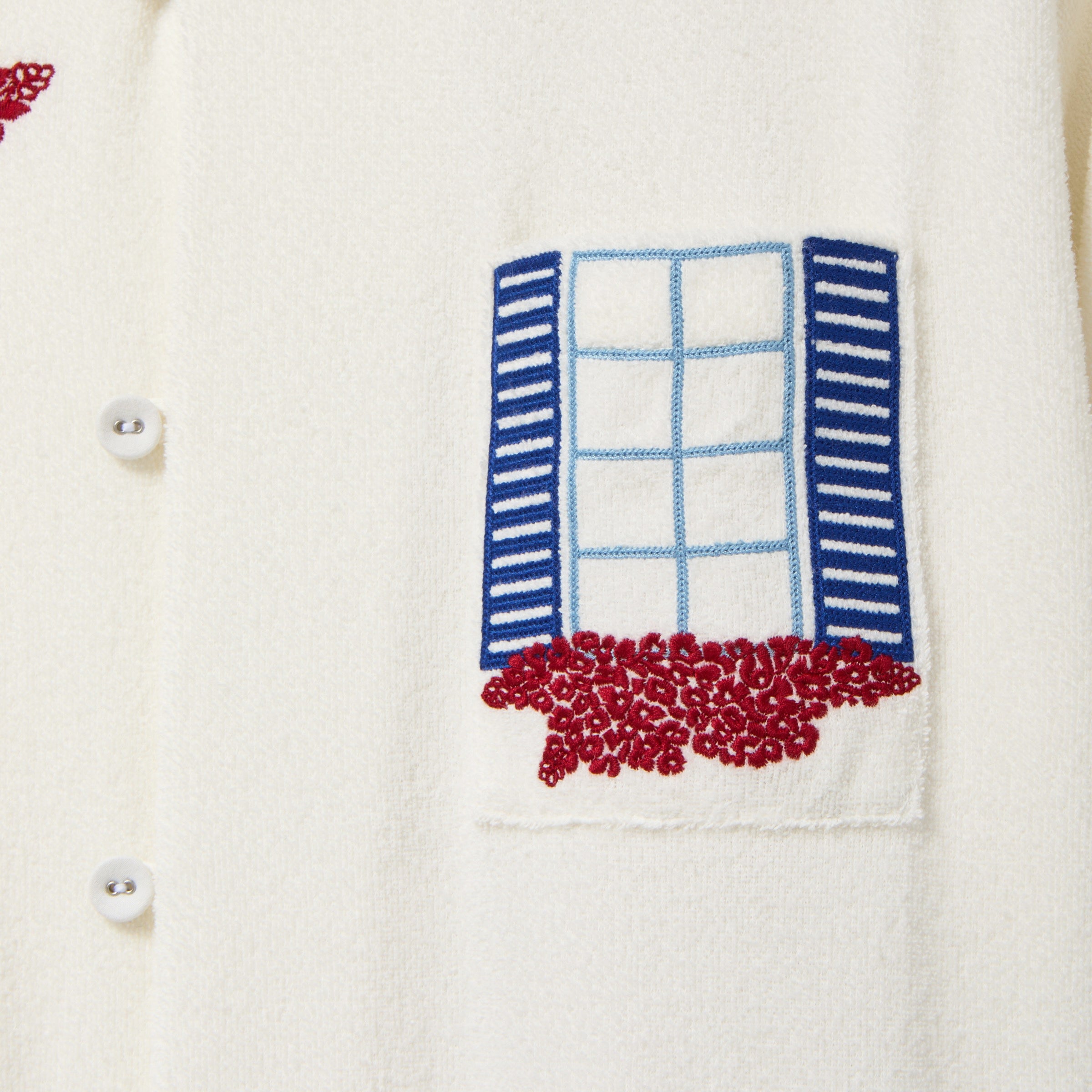 Embroidered design of a window with shutters