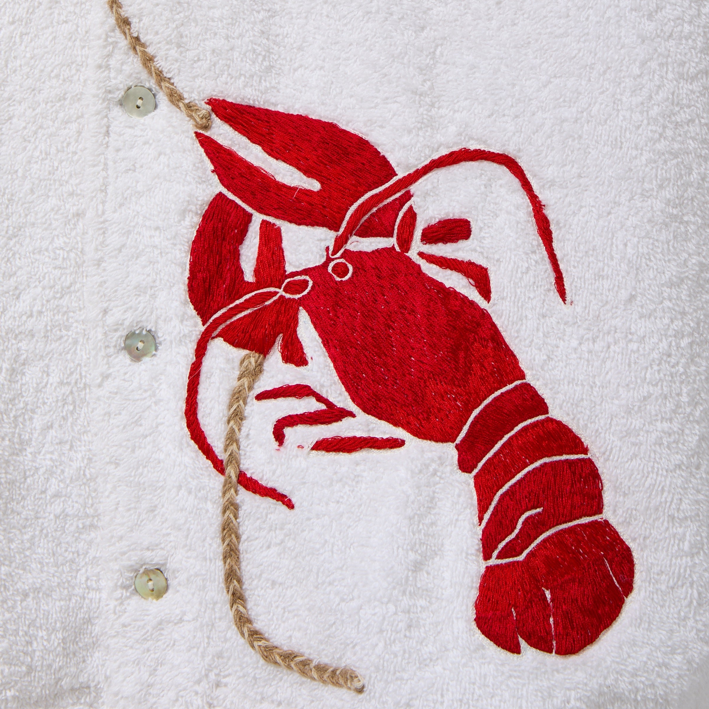 Red embroidered lobster on a white terry cloth background