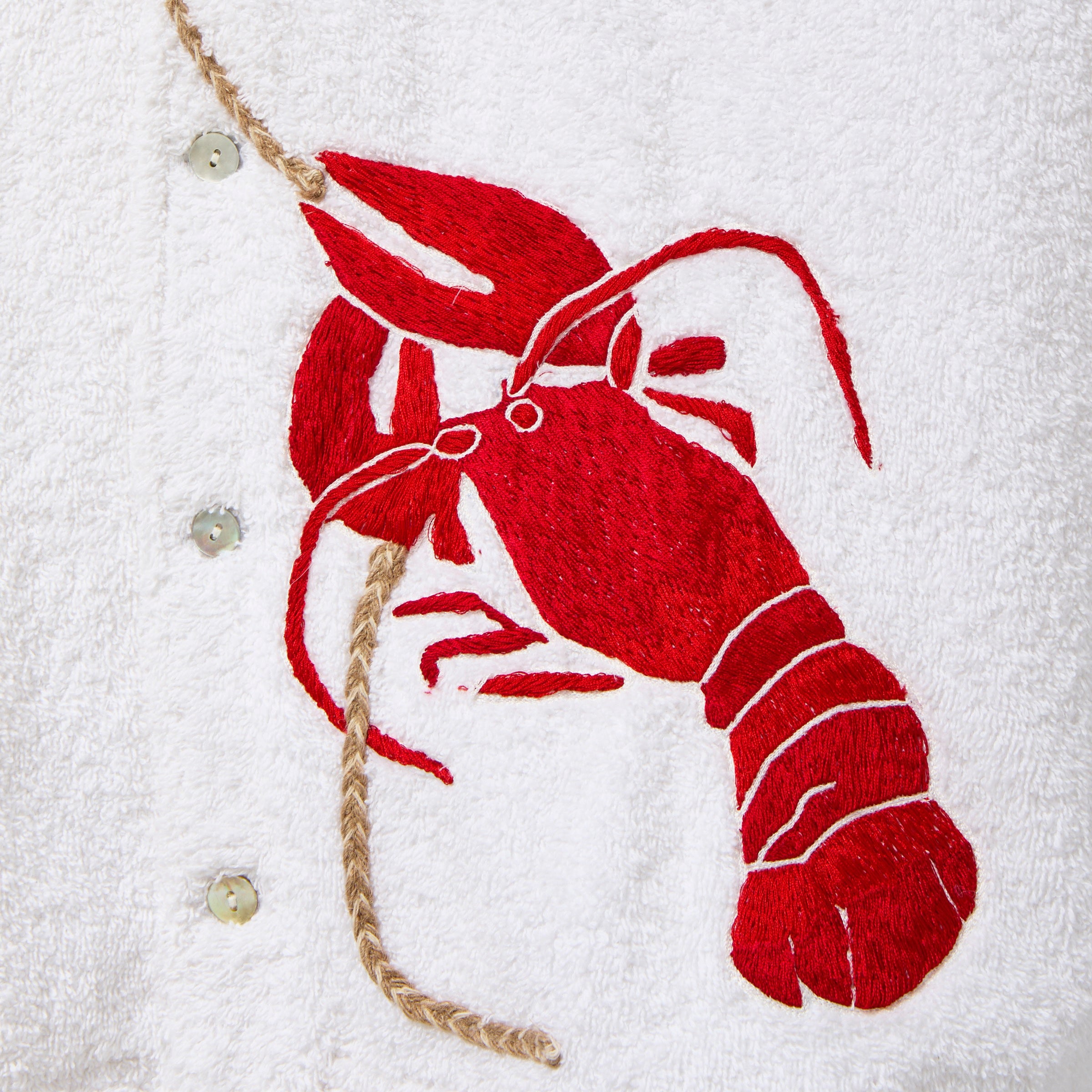 Red embroidered lobster on a white terry cloth background