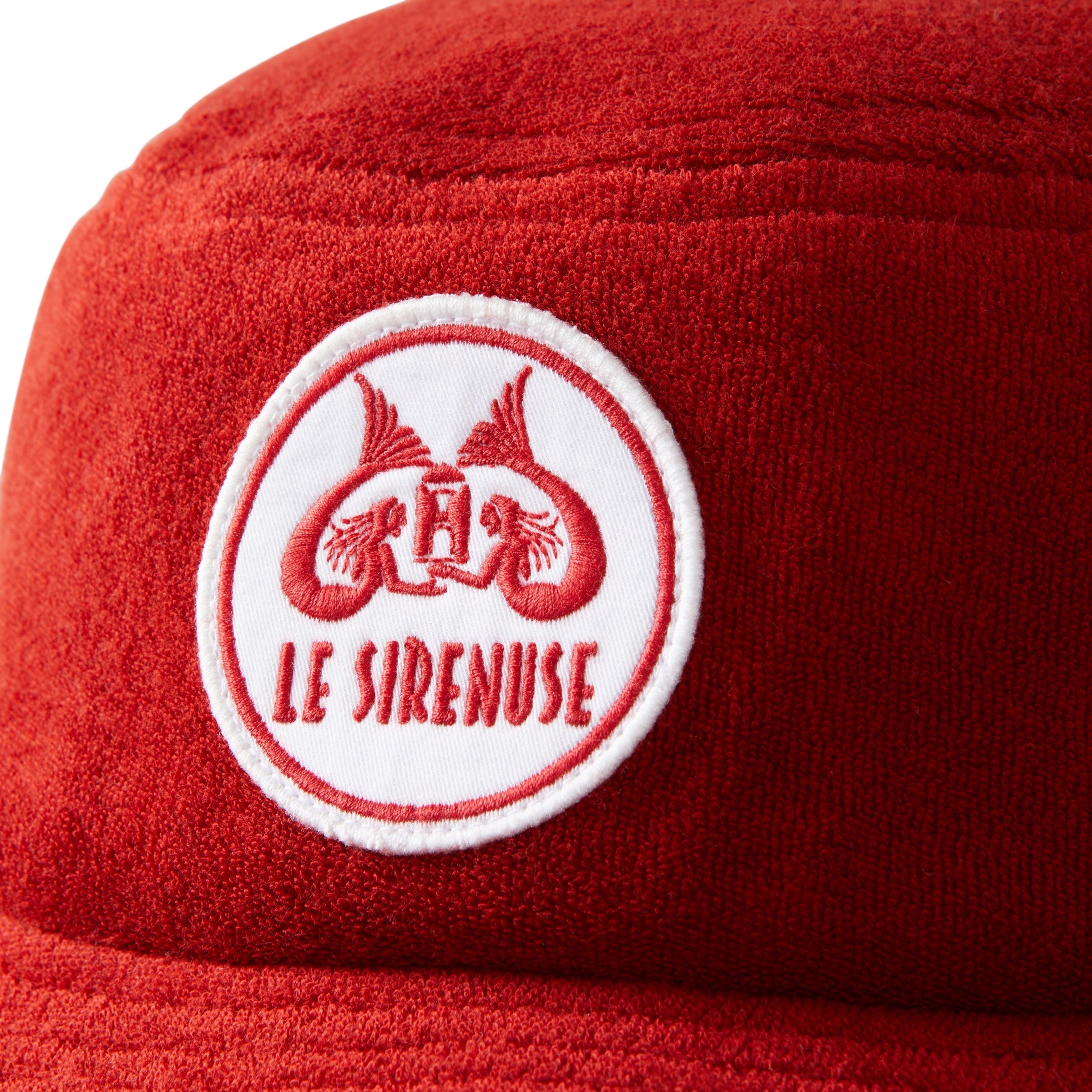 Close-up of Le Sirenuse patch on red terry cloth bucket hat.