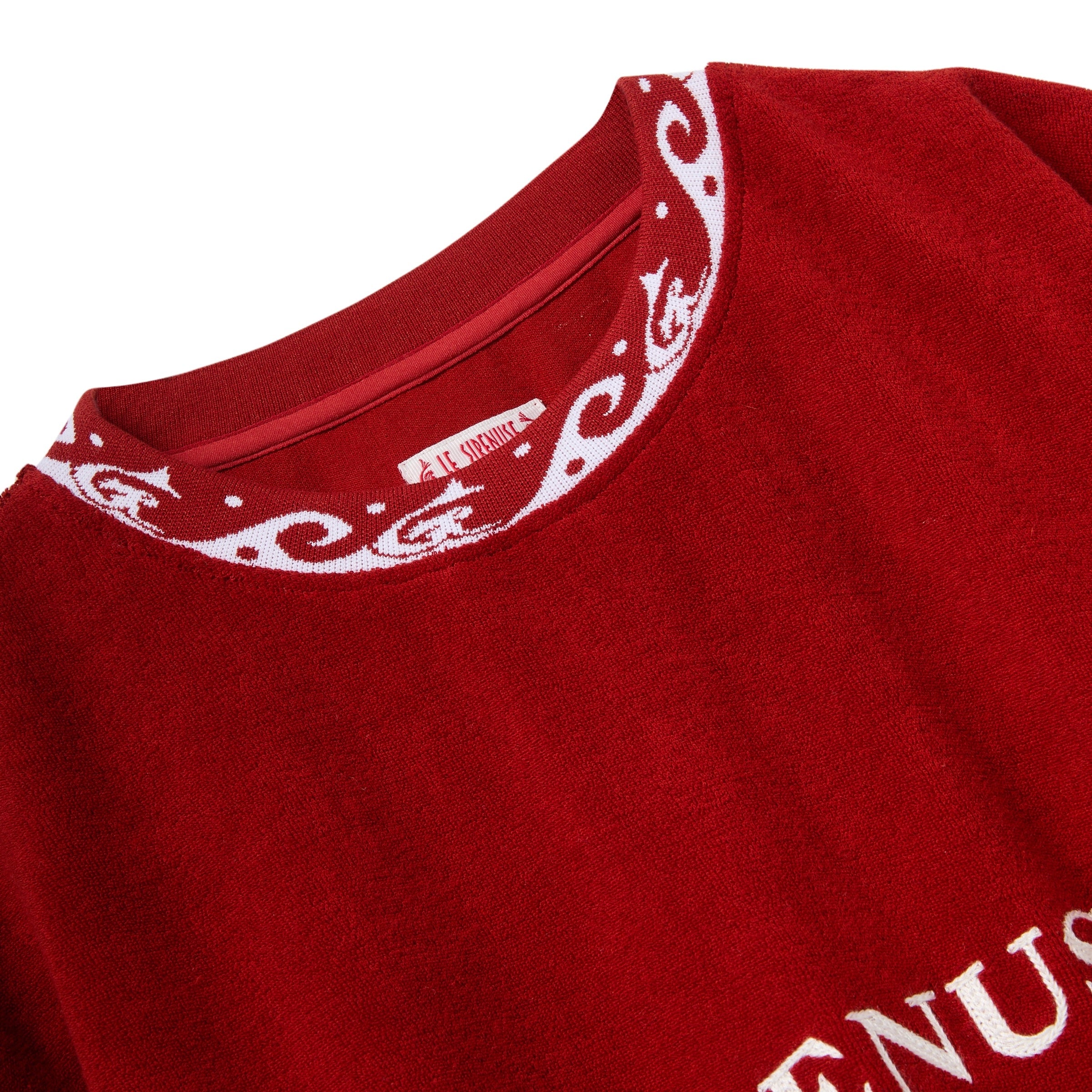 Close-up of a red shirt with white embroidery on a white background
