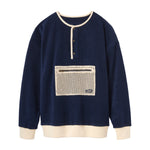 Navy blue pullover with a beige pocket on a white background