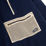 Navy blue shirt with a textured beige pocket and zipper detail