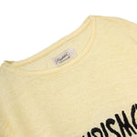 Close-up of a yellow shirt with a brand label on a white background