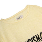Close-up of a yellow shirt with a brand label on a white background