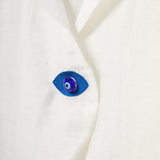 Blue eye-shaped button on a white fabric background