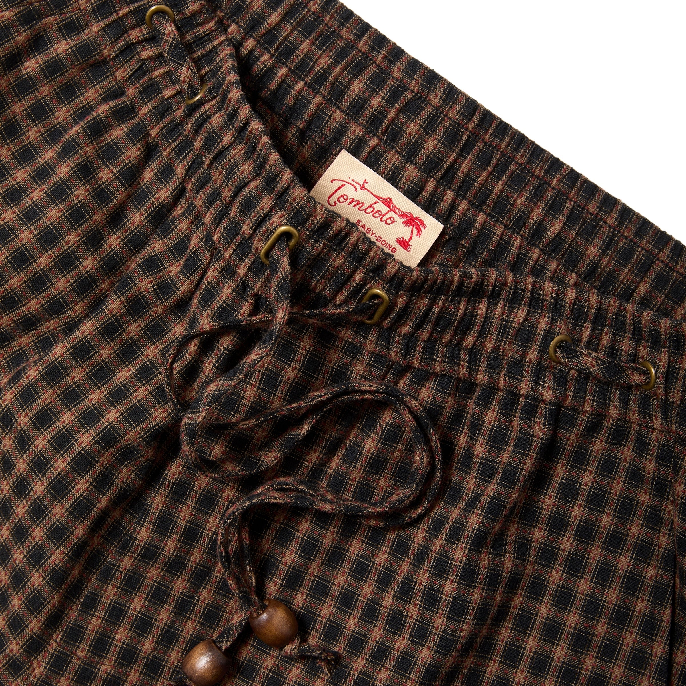 Brown and black checkered pants with a Tombolo label on a white background