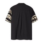 Back of black short sleeve cabana shirt with cream chain-stitch embroidery along the sleeves.