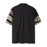 Back of black short sleeve cabana shirt with cream chain-stitch embroidery along the sleeves.
