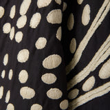 Close-up of black fabric with beige polka dot pattern